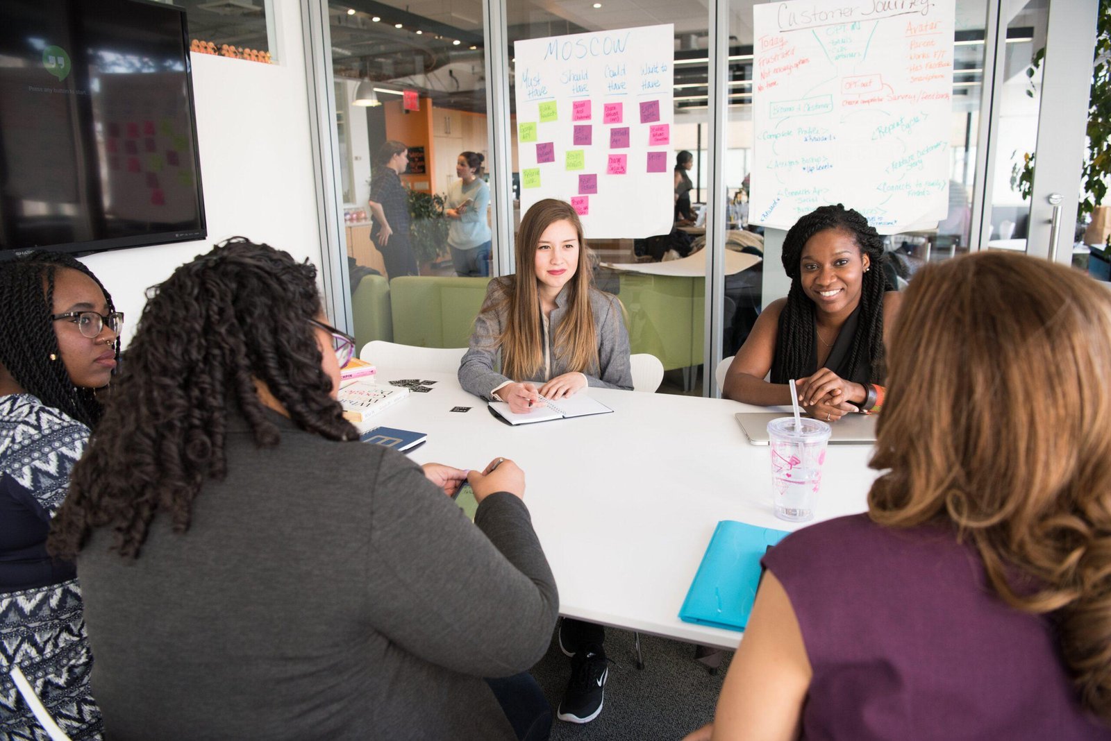 A team sits around a conference room table discussing a project.